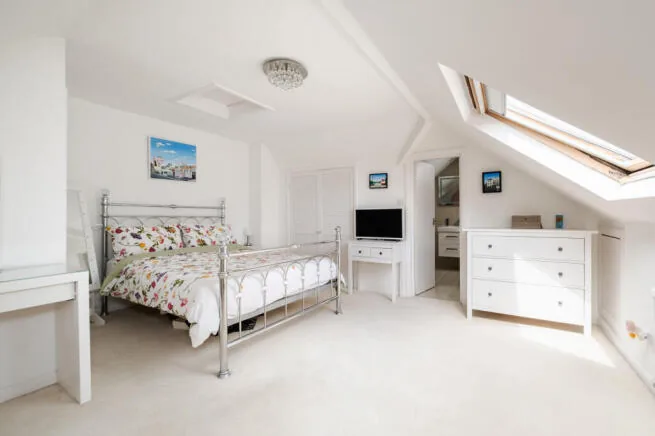 Loft guest bedroom with timber-framed roof windows