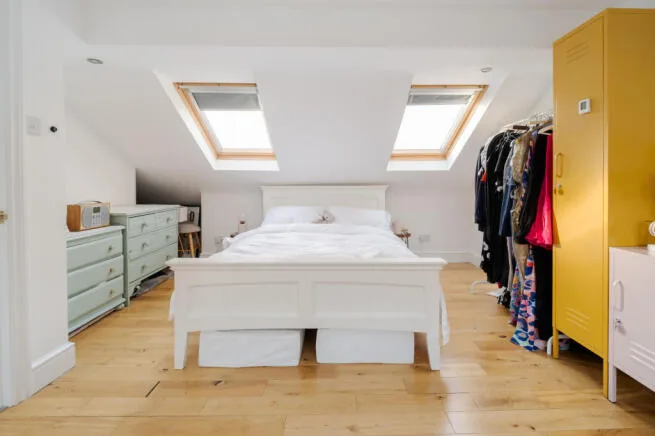 Converted loft bedroom with eaves storage and a roof window